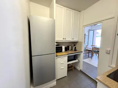 a kitchen with white cabinets and a refrigerator at C OT Maison de la Place - Old Town in Nice