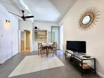 a living room with a television and a table at C OT Maison de la Place - Old Town in Nice