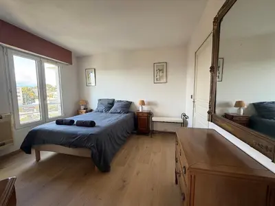 a bedroom with a bed and a large mirror at 3 Pieces st laurent du Var in Saint-Laurent-du-Var