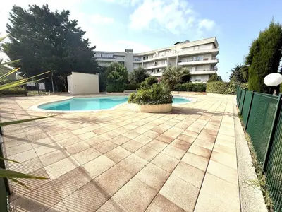 a swimming pool in front of a building at 3 Pieces st laurent du Var in Saint-Laurent-du-Var