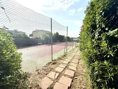 a tennis court with a chain link fence at 3 Pieces st laurent du Var in Saint-Laurent-du-Var