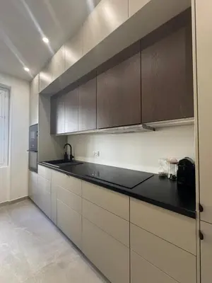 a kitchen with white cabinets and black counter tops at Magnifique appartement dans palais Niçois in Nice