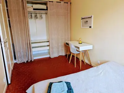 a bedroom with a bed and a desk and a table at Heart of city 62m2 in Nice