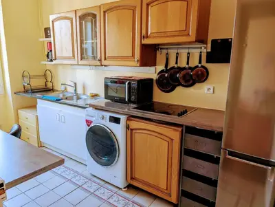 a kitchen with a washing machine and a microwave at Heart of city 62m2 in Nice