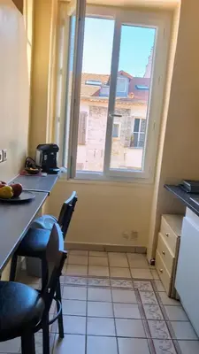 a kitchen with a table and chairs and a window at Heart of city 62m2 in Nice