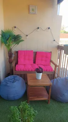 a couch with bright pink pillows and a table at Apartment with balcony 5 minutes walk from the sea in Cagnes-sur-Mer