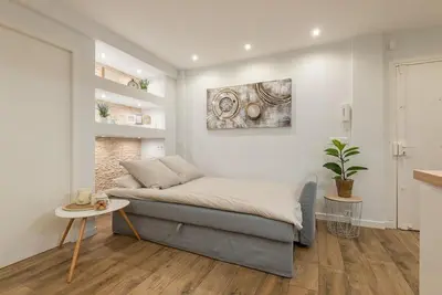 a bedroom with a bed and a table in it at Le Comfy, cosy place dans le vieux nice avec climatisation in Nice