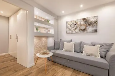 a living room with a gray couch and a table at Le Comfy, cosy place dans le vieux nice avec climatisation in Nice