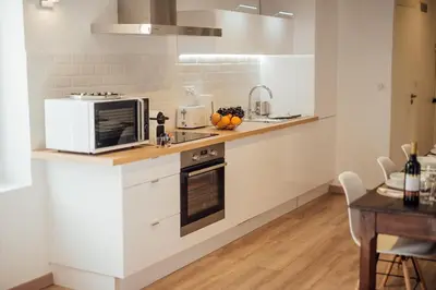 a kitchen with white cabinets and a microwave at L'Authentic, charme dans la vieille ville avec climatisation in Nice