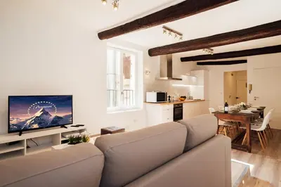 a living room with a couch and a television at L'Authentic, charme dans la vieille ville avec climatisation in Nice