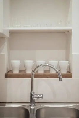 a sink in a kitchen with bowls on a shelf at Le Trendy, plein centre avec climatisation in Nice