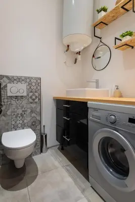 a bathroom with a washing machine and a sink at L'Atelier, loft confortable dans la vieille ville, avec climatisation in Nice