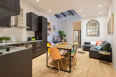 a kitchen and living room with a table and chairs at L'Atelier, loft confortable dans la vieille ville, avec climatisation in Nice