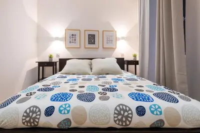 a bedroom with a bed with a blue and white comforter at L'Atelier, loft confortable dans la vieille ville, avec climatisation in Nice