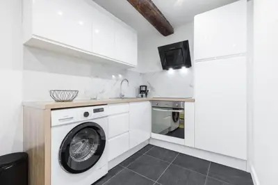 a white kitchen with a washer and dryer at Charmant petit 2 pieces dans la vieille ville in Nice