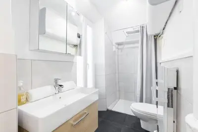 a white bathroom with a sink and a toilet at Charmant petit 2 pieces dans la vieille ville in Nice