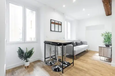 a living room with a table and a couch at Charmant petit 2 pieces dans la vieille ville - B in Nice