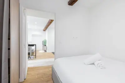 a bedroom with a white bed and a mirror at Charmant petit 2 pieces dans la vieille ville - B in Nice