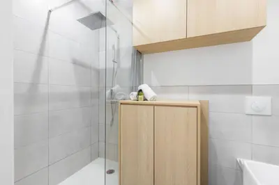 a bathroom with a shower and a wooden cabinet at Charmant petit 2 pieces dans la vieille ville - B in Nice