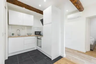 a kitchen with white cabinets and a counter top at Charmant petit 2 pieces dans la vieille ville - B in Nice