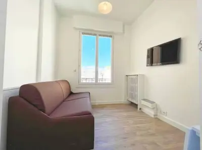 a living room with a couch and a television at Lumineux studio proche Jean Medecin in Nice