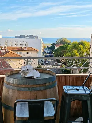 a barrel and chairs on a balcony with a view at Votre grand COCON Niçois Appart Vue Mer in Nice