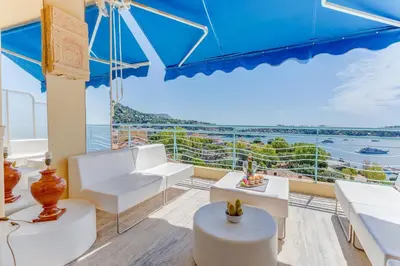 a living room with white furniture and a large window at PANORAMIC ESTEREL AP4475 By Riviera Holiday Homes in Villefranche-sur-Mer