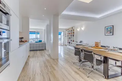 a kitchen and living room with a table and chairs at PANORAMIC ESTEREL AP4475 By Riviera Holiday Homes in Villefranche-sur-Mer