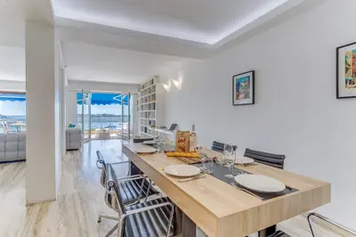 a kitchen with a table and chairs in a room at PANORAMIC ESTEREL AP4475 By Riviera Holiday Homes in Villefranche-sur-Mer