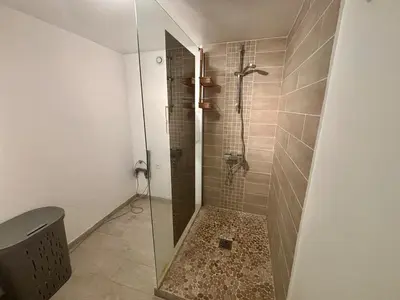 a shower with a glass door in a bathroom at Appartement terrasse jacuzzi in Nice
