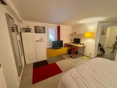 a bedroom with a bed and a desk with a computer at Appartement terrasse jacuzzi in Nice