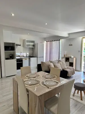 a living room with a table and a couch at Charmant 2pcs - 5min des plages in Cagnes-sur-Mer