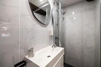 a white bathroom with a sink and a mirror at Two suites with AC in the heart of Old Nice, each with its own entrance in Nice