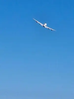 an airplane is flying in the blue sky at T1 Bord De Mer Nice West in Nice