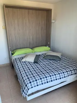 a large bed with two pillows and a headboard at Mer à 5 minutes et vue splendide! in Nice