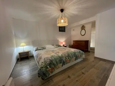 a bedroom with a bed and a chandelier at Le petit Baou in Saint-Jeannet