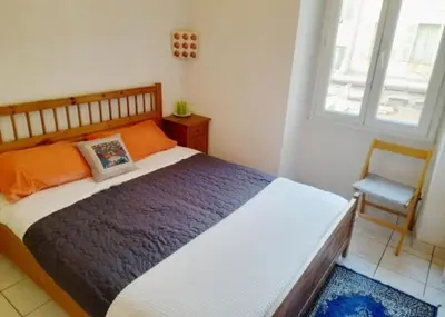 a bedroom with a bed and a chair and a window at Appartement centre ville in Nice