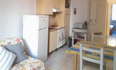 a kitchen with a table and a white refrigerator at Appartement centre ville in Nice