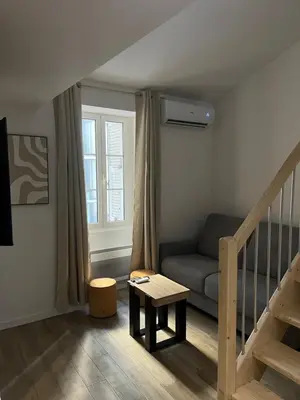 a living room with a couch and a stair case at Appartement confort au cœur de Nice in Nice