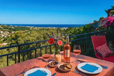 a table with a bottle of wine and wine glasses at Villa Bleu Azur - Élégance Privée avec Vue Mer & Montagne in Cagnes-sur-Mer