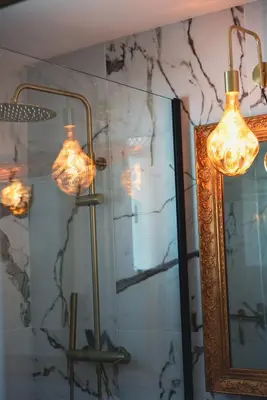 a bathroom with two lights and a mirror at Villa Bleu Azur - Élégance Privée avec Vue Mer & Montagne in Cagnes-sur-Mer