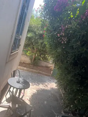 a patio with a table and chairs and flowers at Haut de maison niçoise - Calme, Charme et Vu Dégagée sur les Collines in Nice