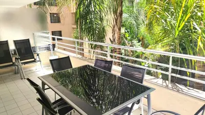 a table and chairs on a balcony with palm trees at Superbe appartement carre d or in Nice