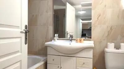 a bathroom with a sink and a toilet and a mirror at Superbe appartement carre d or in Nice