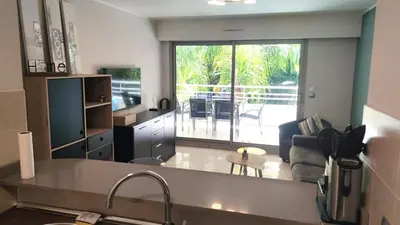 a kitchen and living room with a view of a patio at Superbe appartement carre d or in Nice