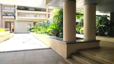 a lobby of a building with columns and plants at Superbe appartement carre d or in Nice