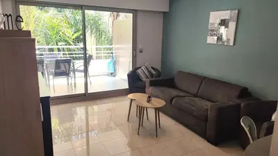 a living room with a couch and a table at Superbe appartement carre d or in Nice