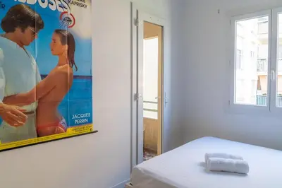 a movie poster on a wall next to a bed at 2 pièces - Clim - tram à 5' centre à 15' in Nice