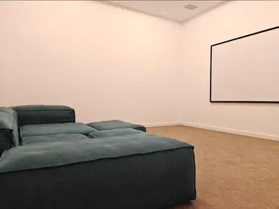 a living room with a couch and a white wall at Contemporary Villa with Sea View, Infinity Swimming pool, Gym , Cinema room,Lift in Nice