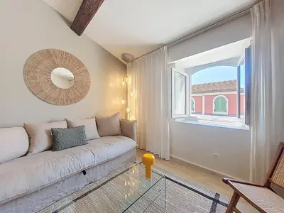 a living room with a couch and a window at Nestor&Jeeves - BEIGE RIVIERA - Standing suite in Nice